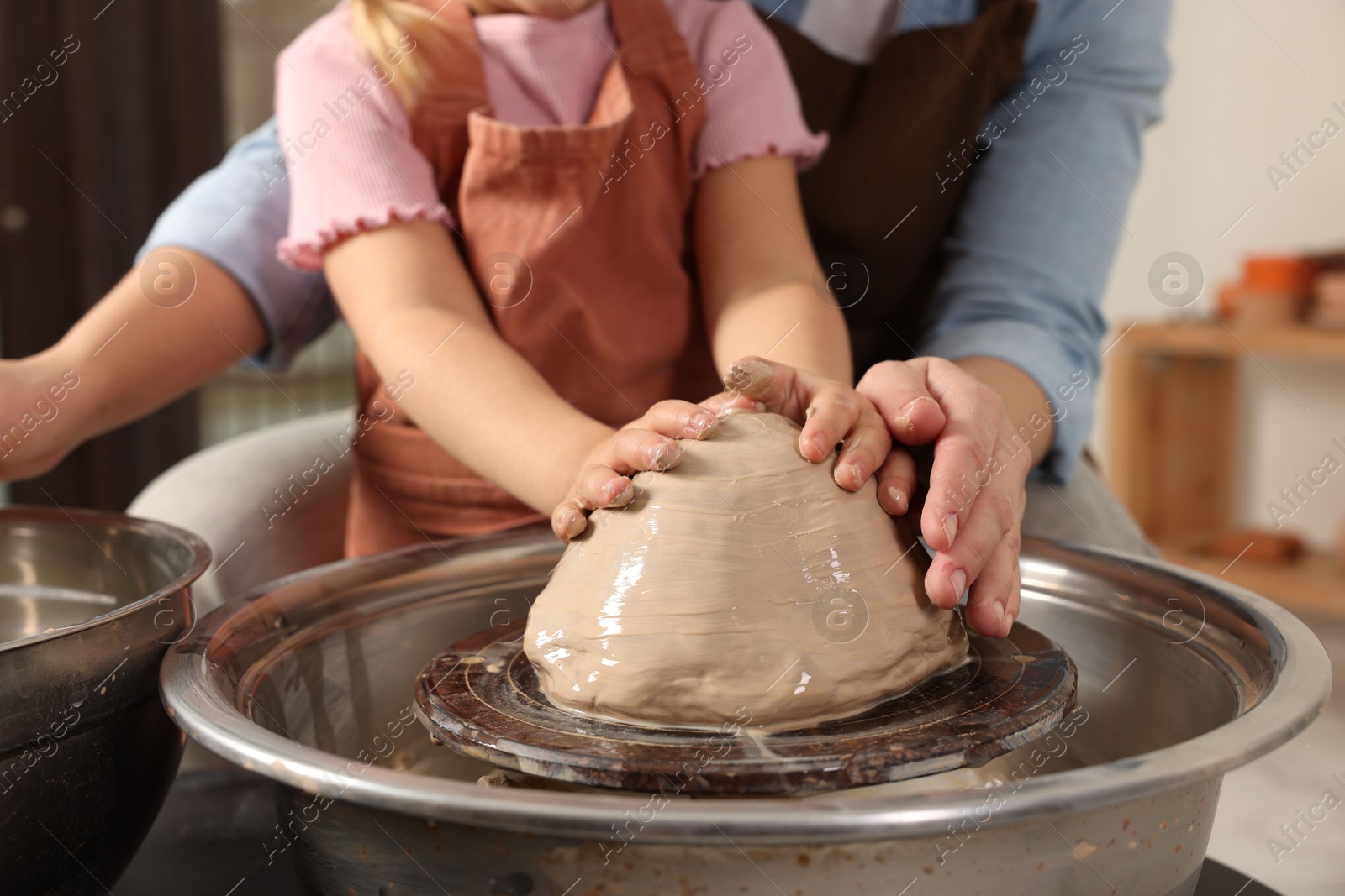 Photo of Hobby and craft. Mother with her daughter making pottery indoors, closeup