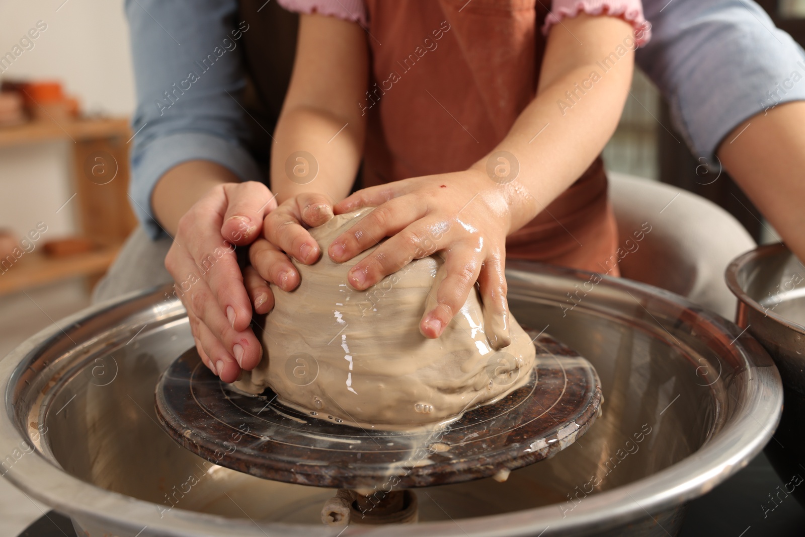 Photo of Hobby and craft. Mother with her daughter making pottery indoors, closeup