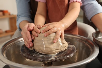 Photo of Hobby and craft. Mother with her daughter making pottery indoors, closeup