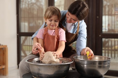 Photo of Hobby and craft. Mother with her daughter making pottery indoors