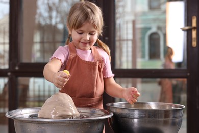 Photo of Hobby and craft. Little girl making pottery indoors