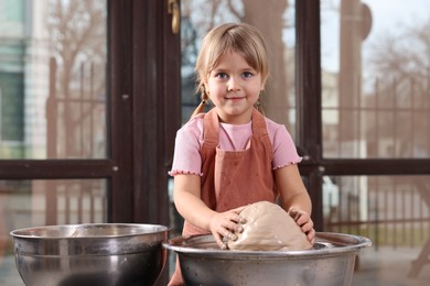 Photo of Hobby and craft. Little girl making pottery indoors