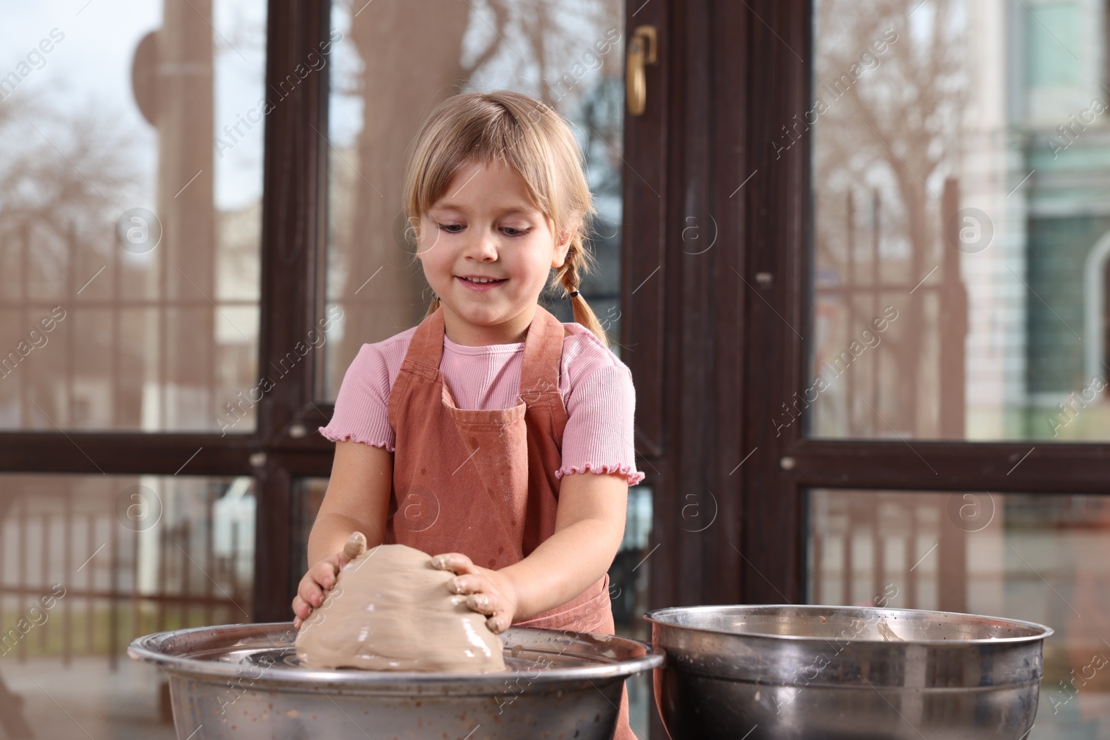 Photo of Hobby and craft. Smiling girl making pottery indoors