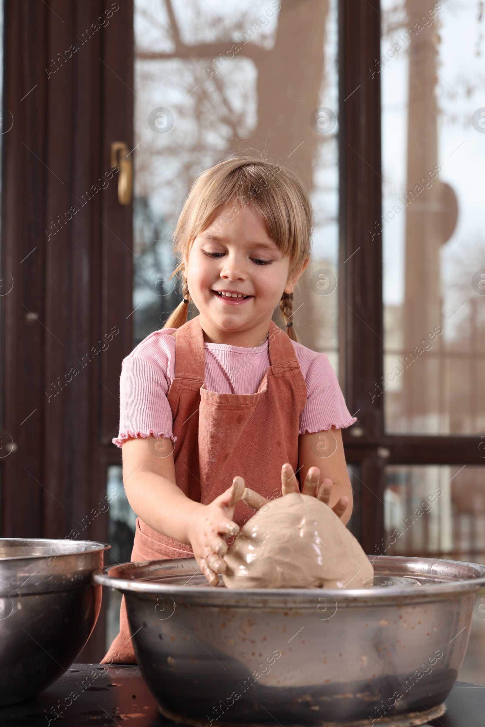 Photo of Hobby and craft. Smiling girl making pottery indoors