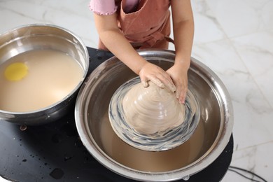 Photo of Hobby and craft. Girl making pottery indoors, closeup