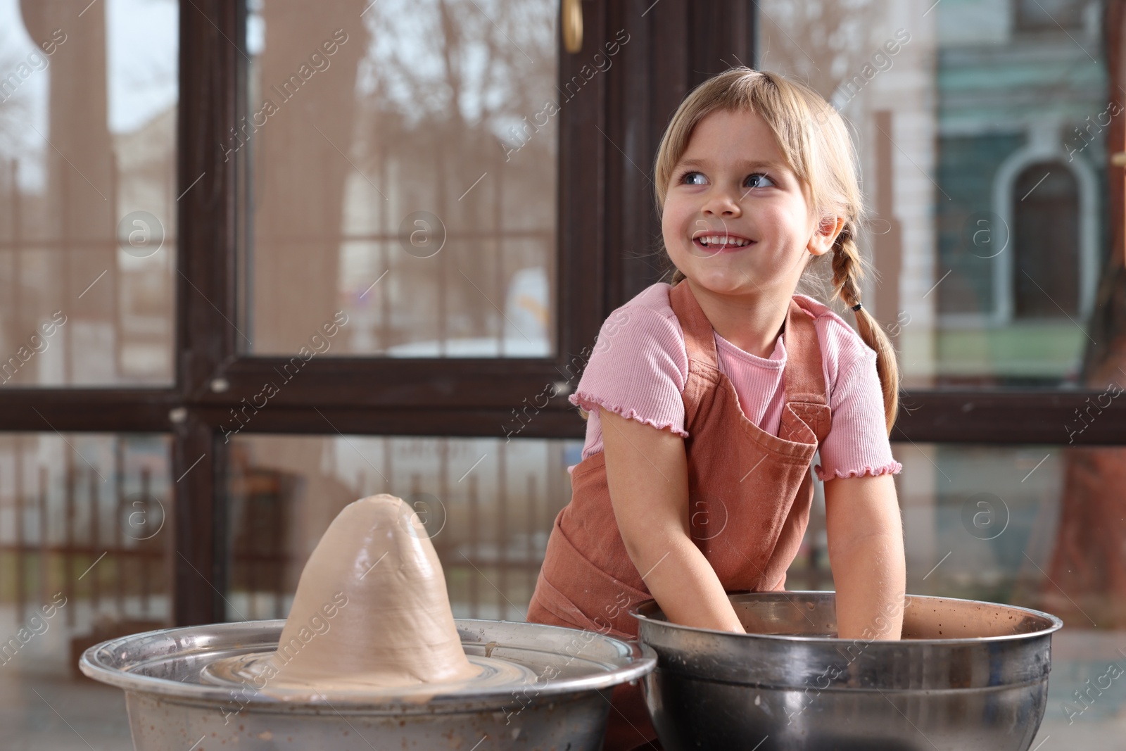 Photo of Hobby and craft. Smiling girl making pottery indoors