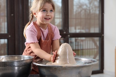 Photo of Hobby and craft. Smiling girl making pottery indoors