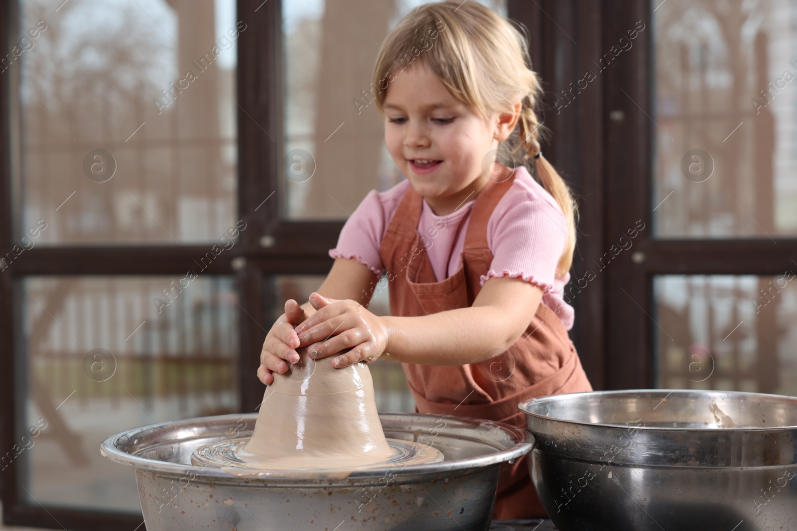 Photo of Hobby and craft. Smiling girl making pottery indoors