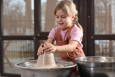 Photo of Hobby and craft. Smiling girl making pottery indoors