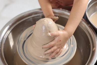 Photo of Hobby and craft. Girl making pottery indoors, closeup