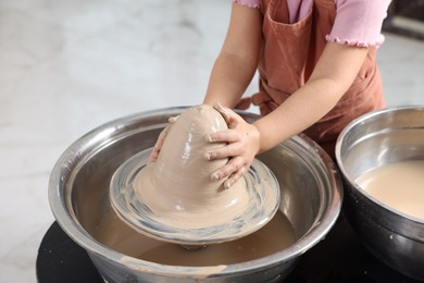 Photo of Hobby and craft. Girl making pottery indoors, closeup