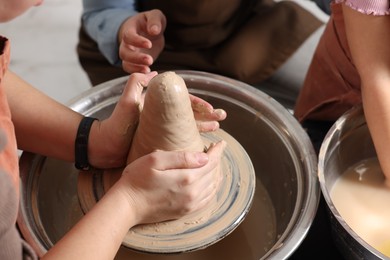 Photo of Hobby and craft. Women with girl making pottery indoors, closeup