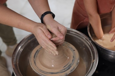 Photo of Hobby and craft. Mother with her daughter making pottery indoors, closeup