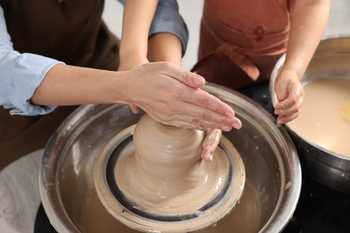 Photo of Hobby and craft. Mother with her daughter making pottery indoors, closeup