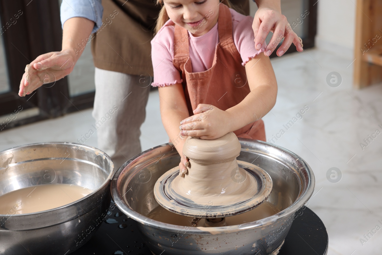 Photo of Hobby and craft. Daughter with her mother making pottery indoors, closeup