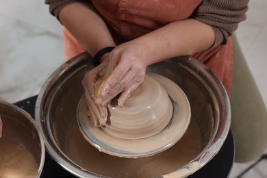 Photo of Hobby and craft. Woman making pottery indoors, closeup