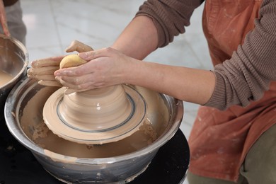 Photo of Hobby and craft. Woman making pottery indoors, closeup