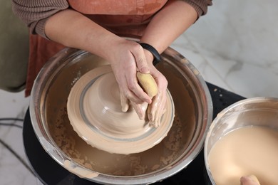 Photo of Hobby and craft. Woman making pottery indoors, closeup