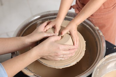 Photo of Hobby and craft. Mother with her daughter making pottery indoors, closeup