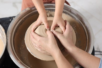 Photo of Hobby and craft. Mother with her daughter making pottery indoors, closeup