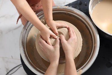 Photo of Hobby and craft. Mother with her daughter making pottery indoors, closeup