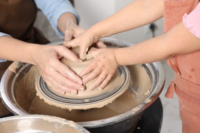 Photo of Hobby and craft. Mother with her daughter making pottery indoors, closeup