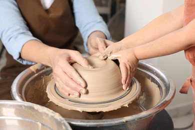 Photo of Hobby and craft. Mother with her daughter making pottery indoors, closeup