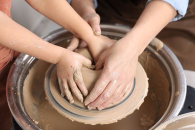 Photo of Hobby and craft. Mother with her daughter making pottery indoors, closeup