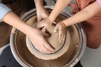 Photo of Hobby and craft. Mother with her daughter making pottery indoors, closeup