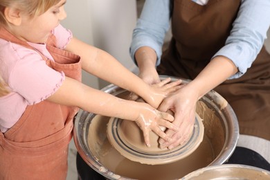 Photo of Hobby and craft. Daughter with her mother making pottery indoors, closeup