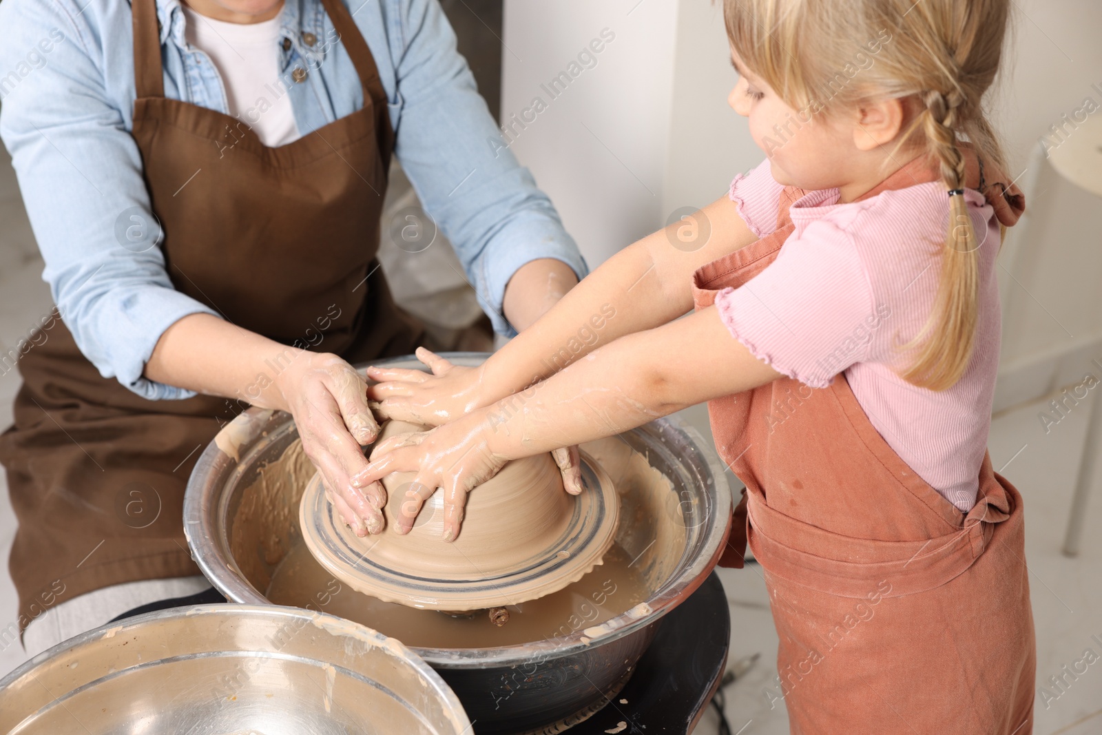 Photo of Hobby and craft. Daughter with her mother making pottery indoors, closeup