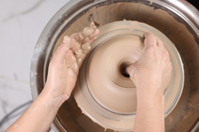 Photo of Hobby and craft. Woman making pottery indoors, above view