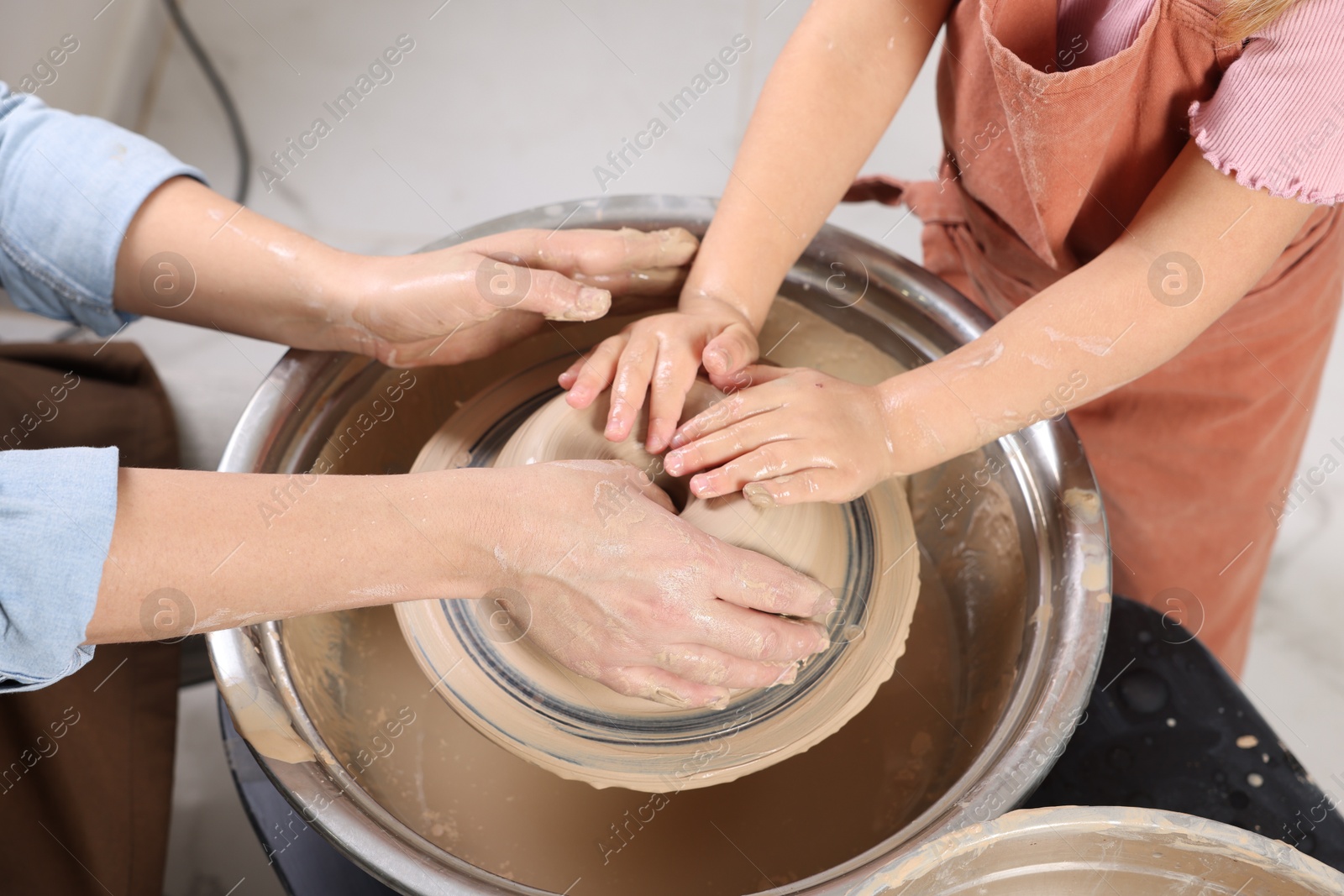 Photo of Hobby and craft. Mother with her daughter making pottery indoors, closeup