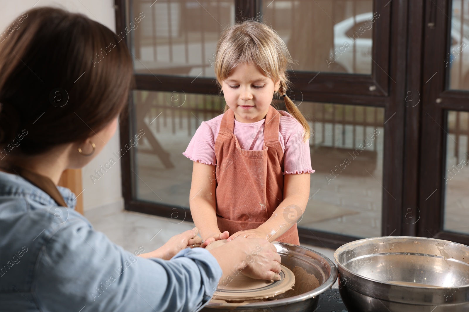 Photo of Hobby and craft. Daughter with her mother making pottery indoors