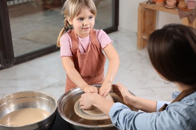 Photo of Hobby and craft. Daughter with her mother making pottery indoors