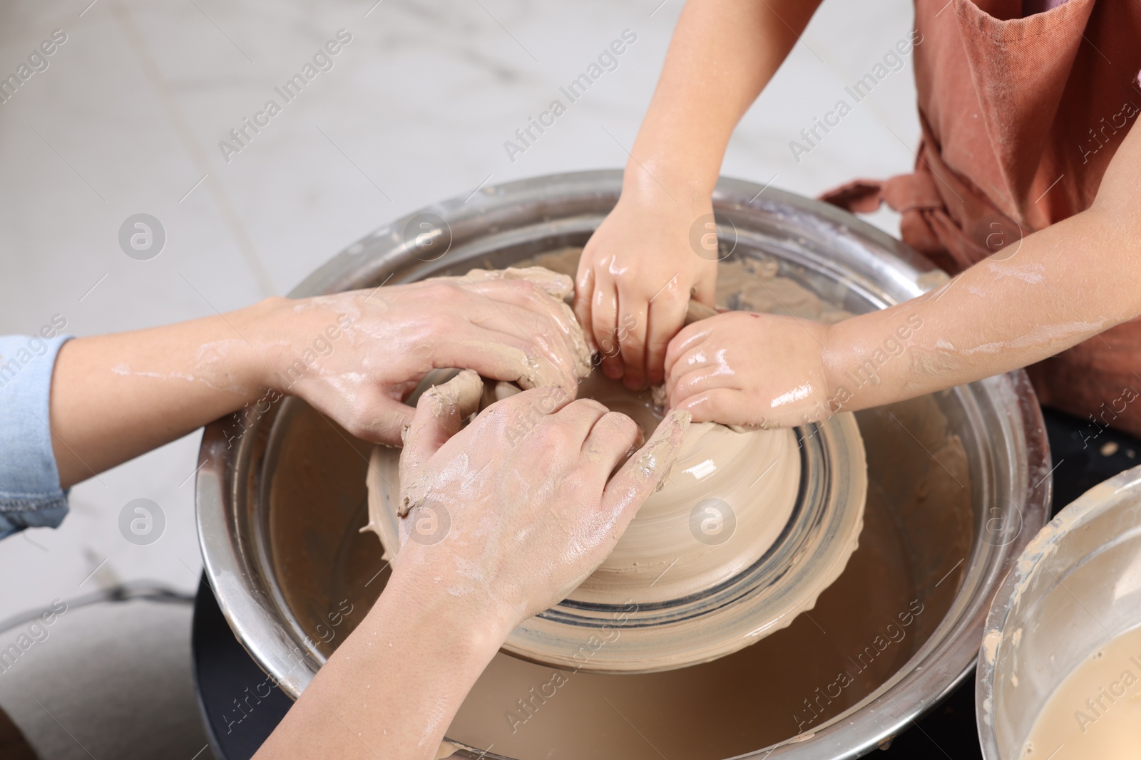 Photo of Hobby and craft. Mother with her daughter making pottery indoors, closeup