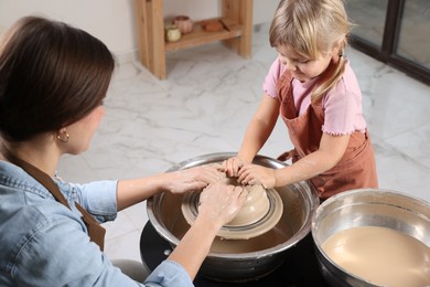 Photo of Hobby and craft. Daughter with her mother making pottery indoors