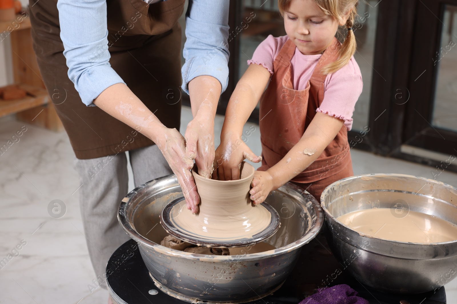 Photo of Hobby and craft. Daughter with her mother making pottery indoors, closeup