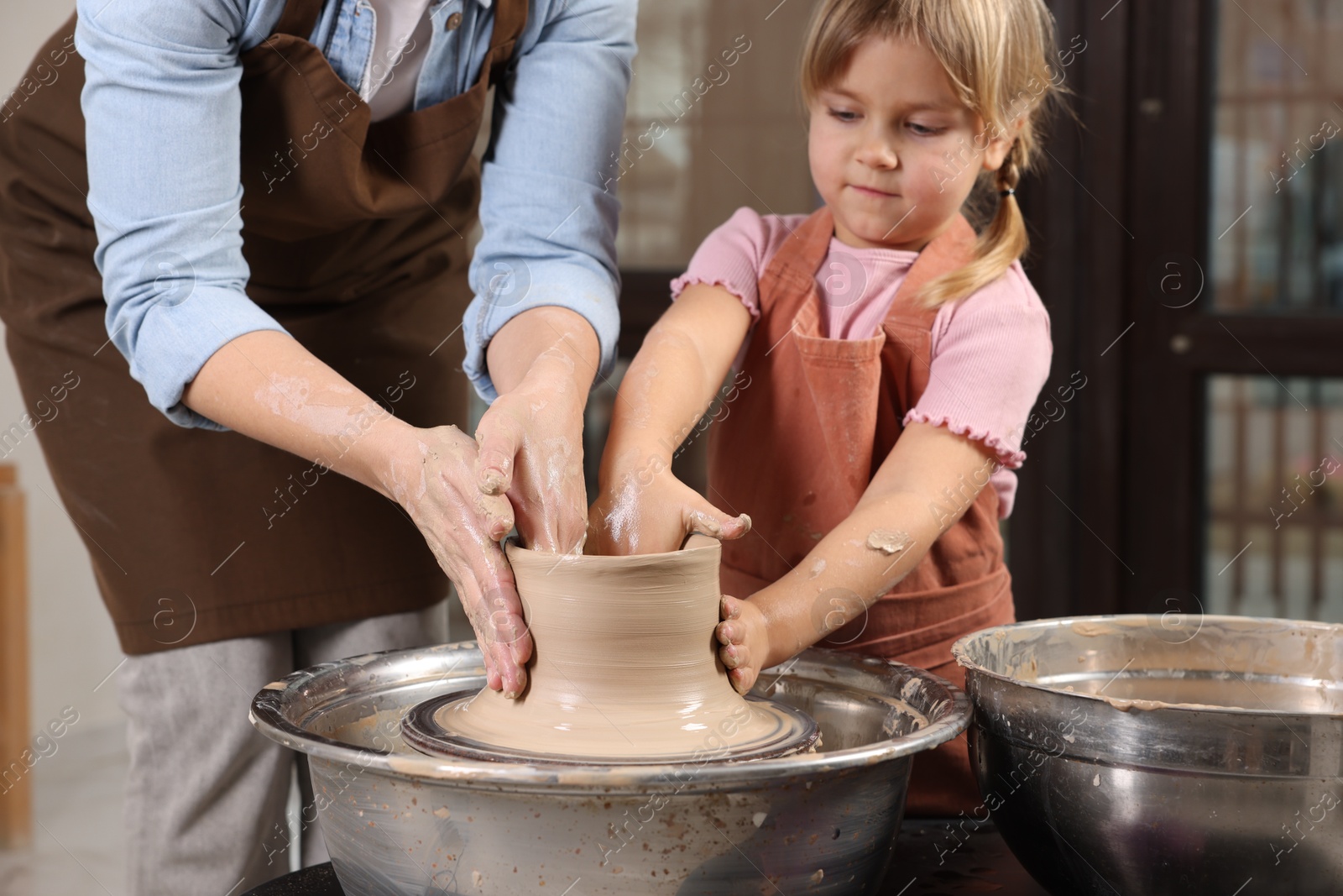 Photo of Hobby and craft. Daughter with her mother making pottery indoors, closeup