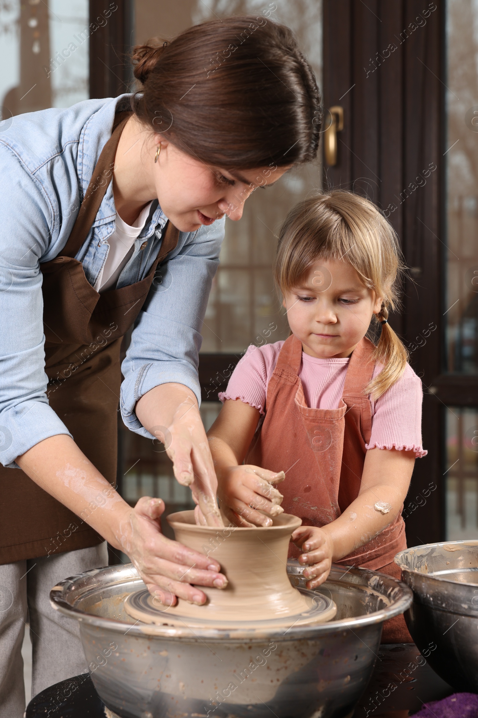 Photo of Hobby and craft. Mother with her daughter making pottery indoors