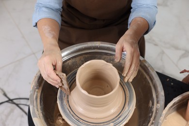 Photo of Hobby and craft. Woman making pottery indoors, closeup