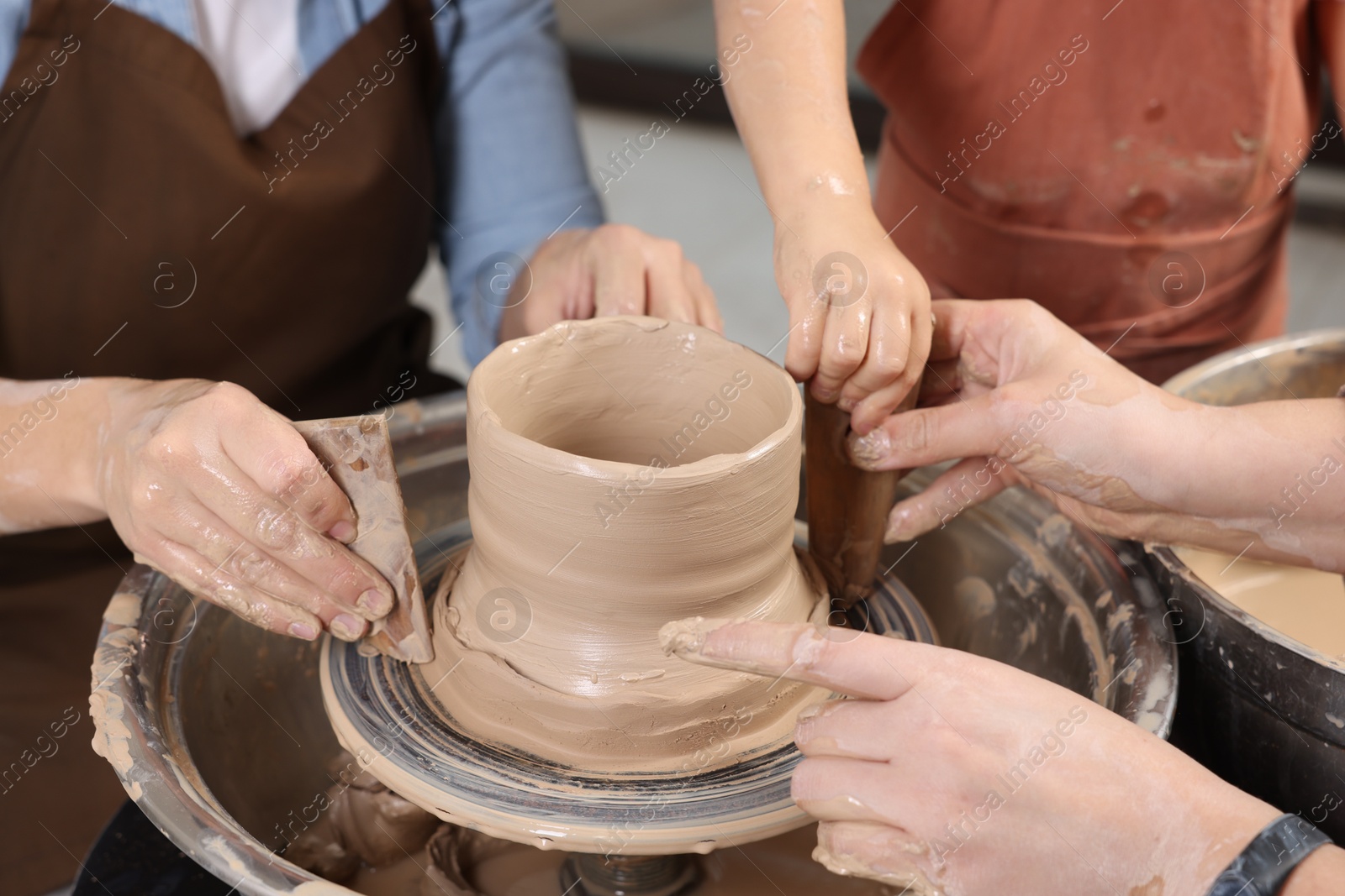 Photo of Hobby and craft. Women with girl making pottery indoors, closeup