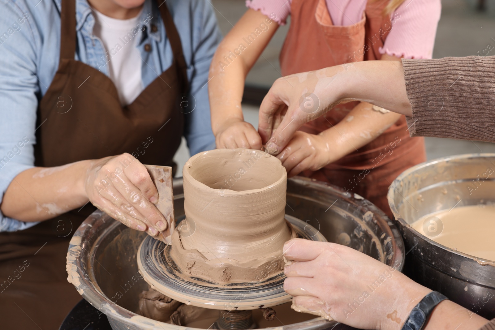 Photo of Hobby and craft. Women with girl making pottery indoors, closeup