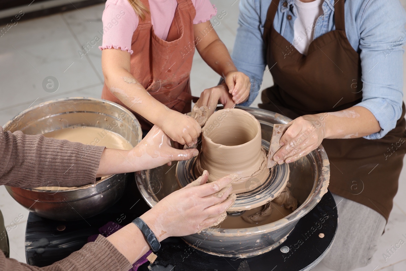 Photo of Hobby and craft. Women with girl making pottery indoors, closeup