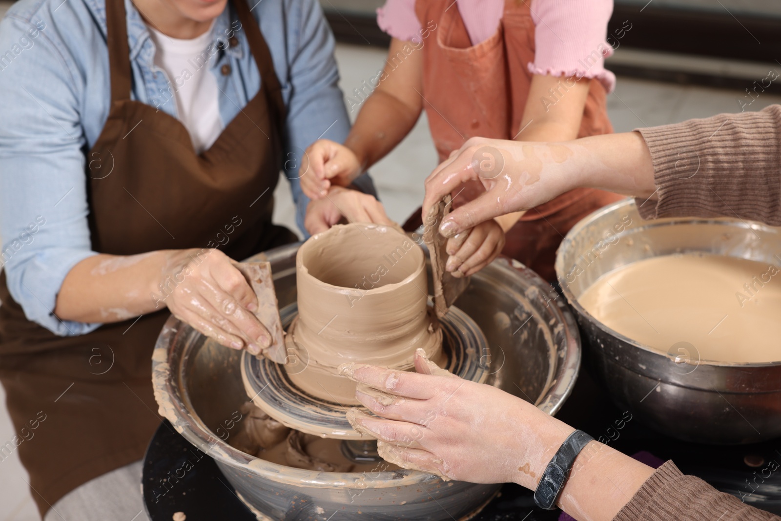 Photo of Hobby and craft. Women with girl making pottery indoors, closeup