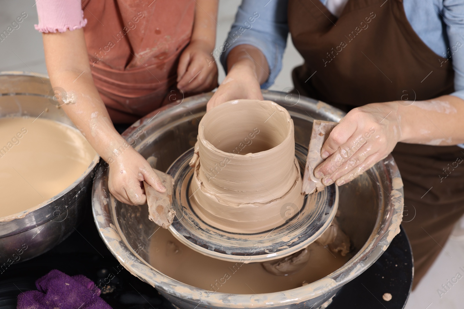 Photo of Hobby and craft. Mother with her daughter making pottery indoors, closeup