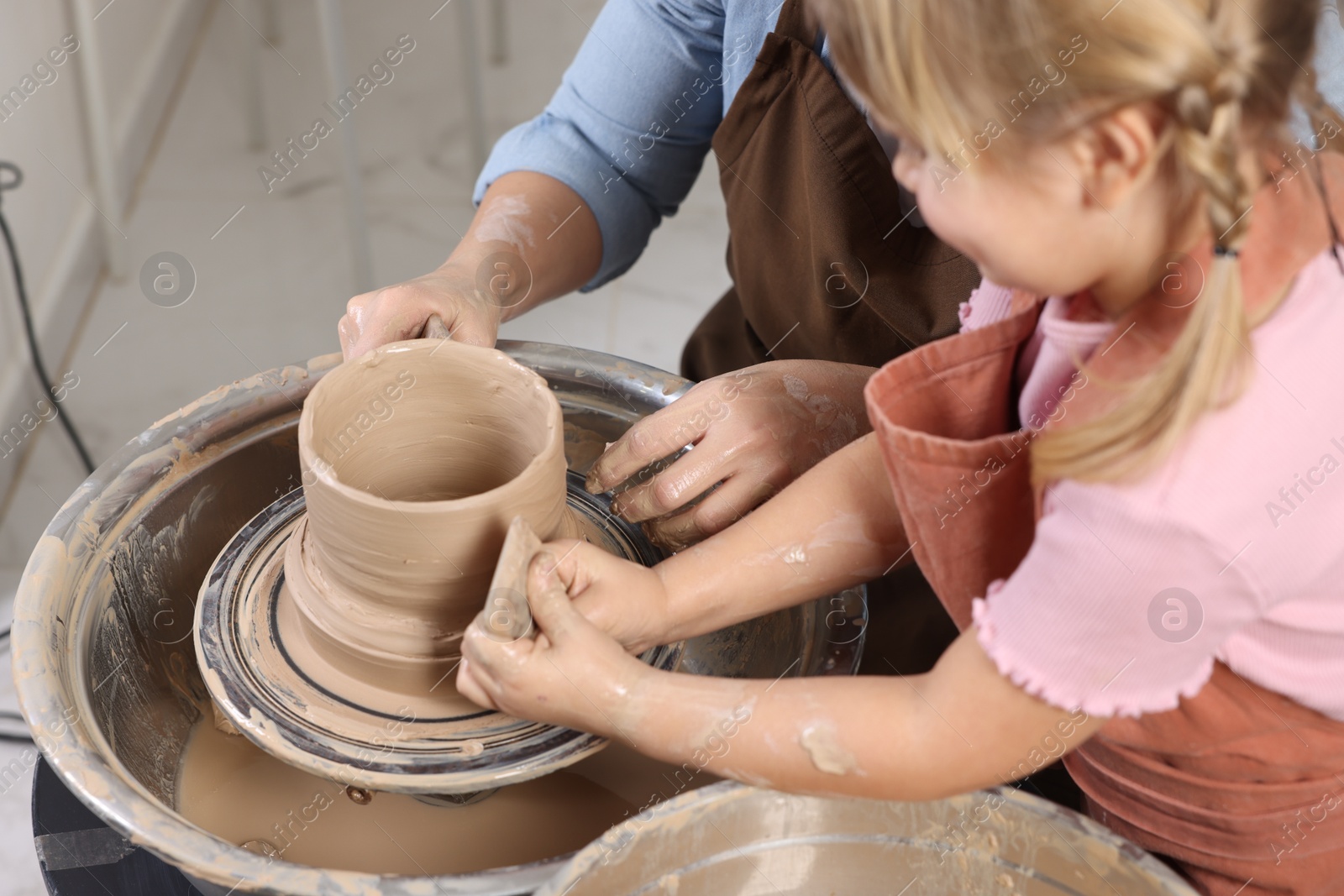 Photo of Hobby and craft. Daughter with her mother making pottery indoors, closeup