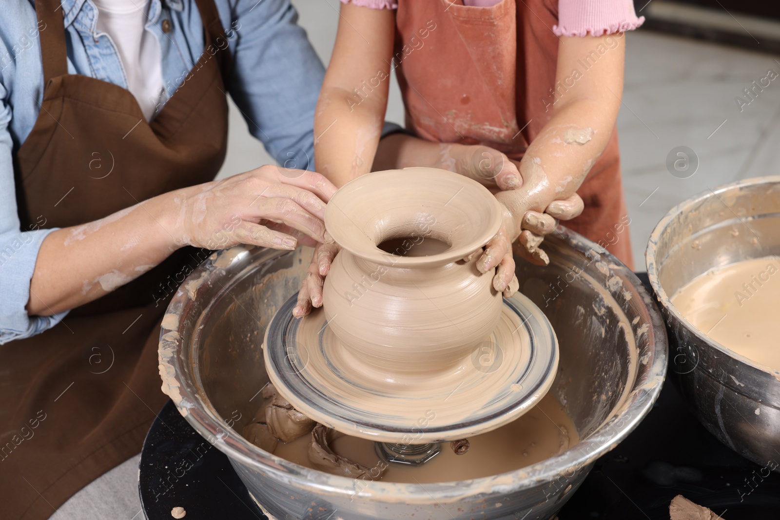 Photo of Hobby and craft. Mother with her daughter making pottery indoors, closeup