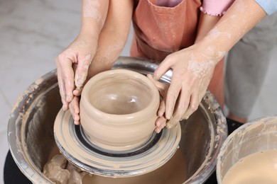 Photo of Hobby and craft. Daughter with her mother making pottery indoors, closeup