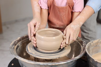 Photo of Hobby and craft. Daughter with her mother making pottery indoors, closeup